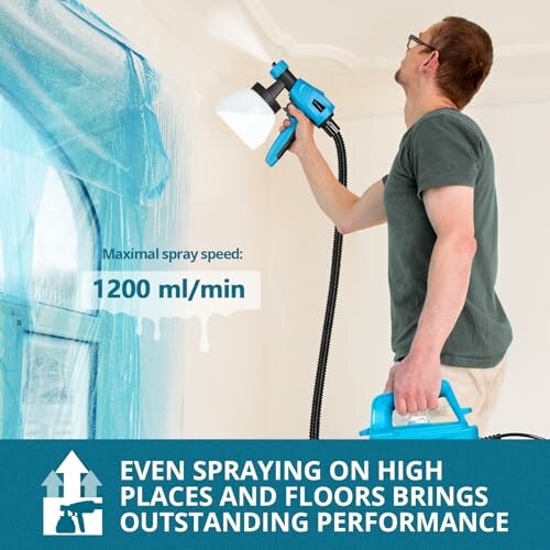 Hombre usando pulverizador de pintura en pared.