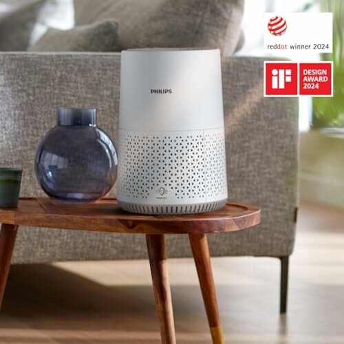 Purificador de aire Philips en una mesa junto a un sofá.