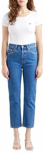 Mujer con camiseta blanca y jeans azules.
